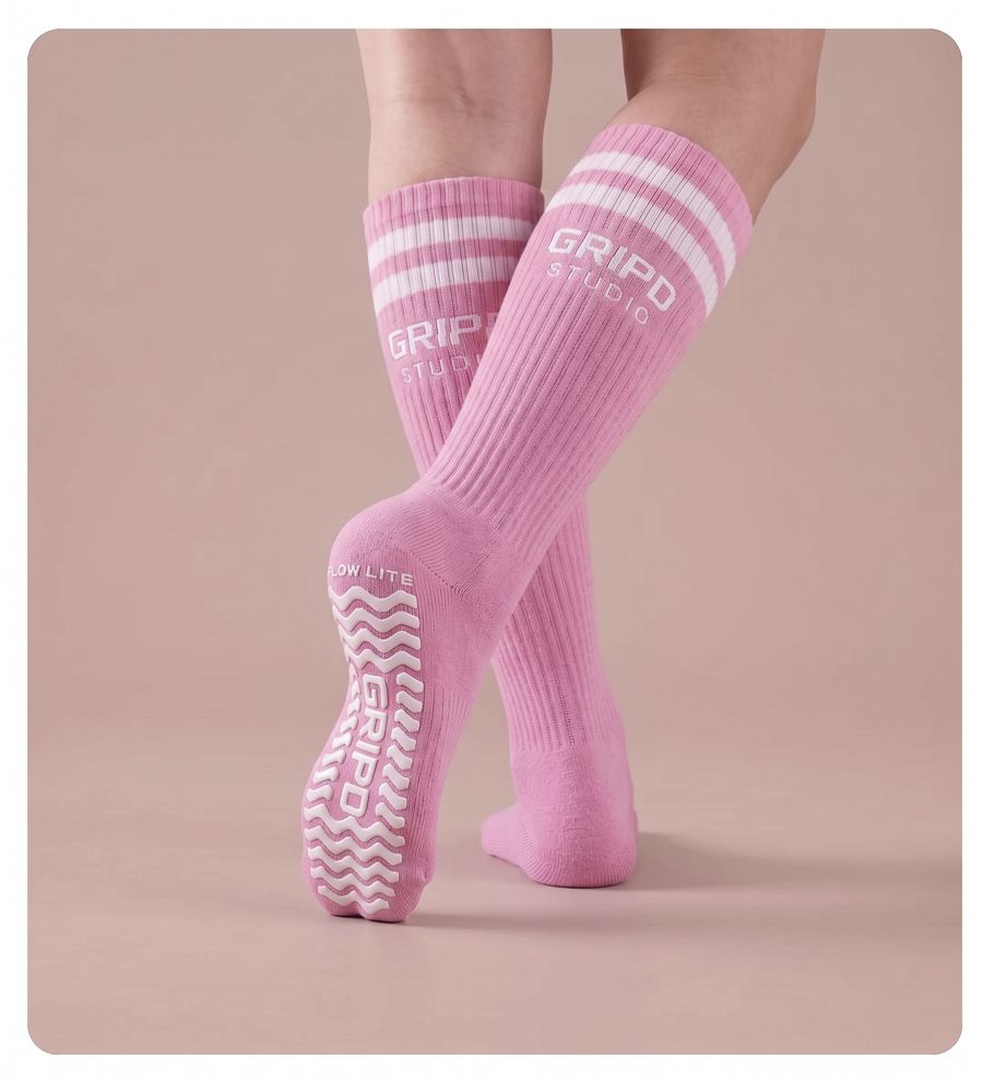 Flow Lite knee-high grip sock, pink with white stripes, showing the moulded silicone sole