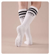 Flow Lite knee-high grip sock, white with black stripes, showing the moulded silicone sole