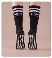 Flow Lite knee-high grip socks, black with white stripes, rear view showing both soles