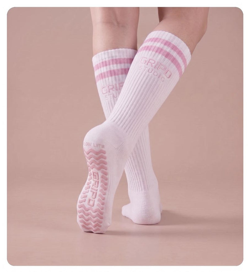 Flow Lite knee-high grip sock, white with pink stripes, showing the moulded silicone sole